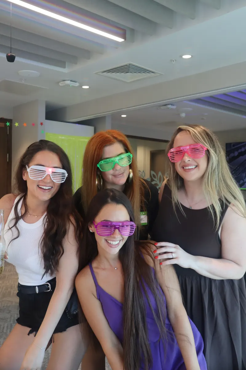 Friends with colourful glasses at summer party photo booth