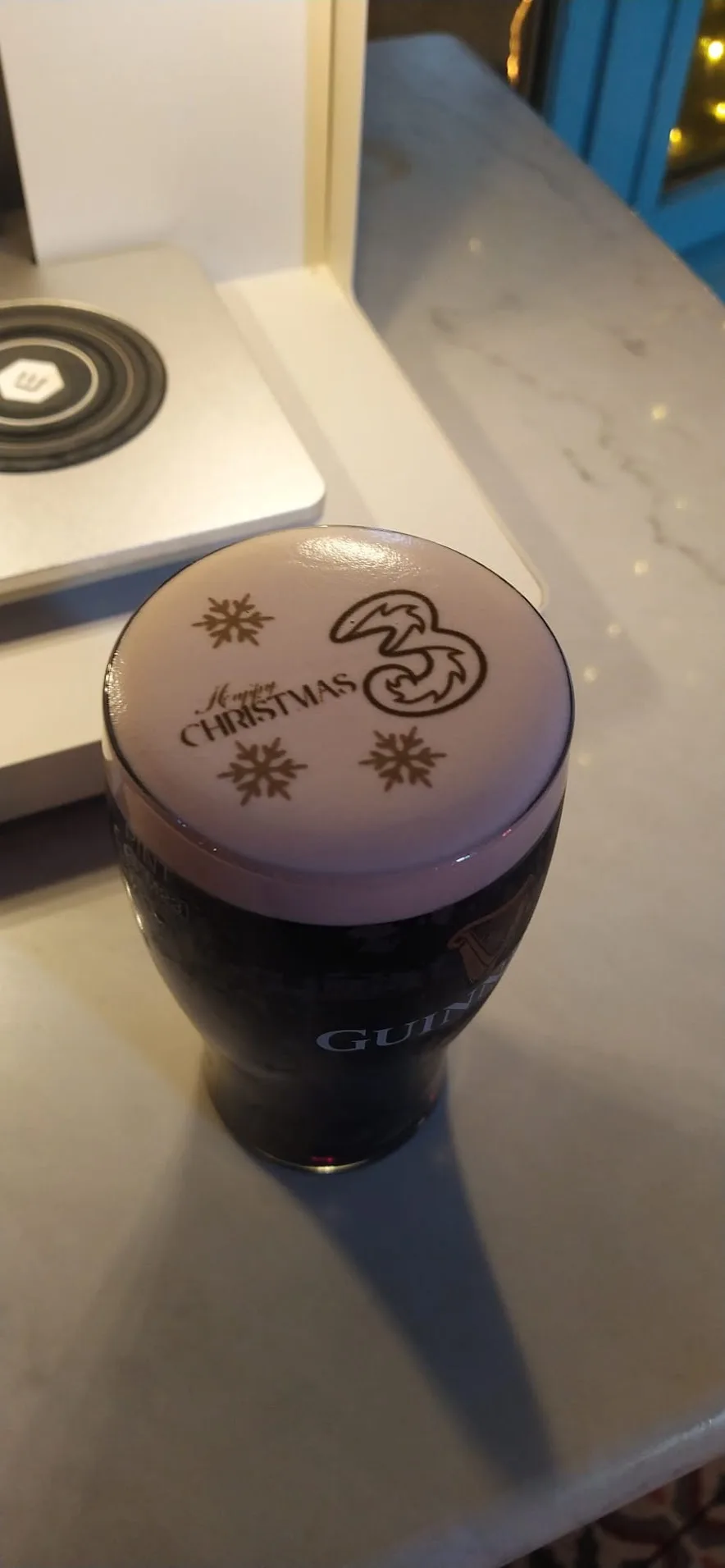 A pint of Guinness with a logo printed on the head by the Guinness pint printer