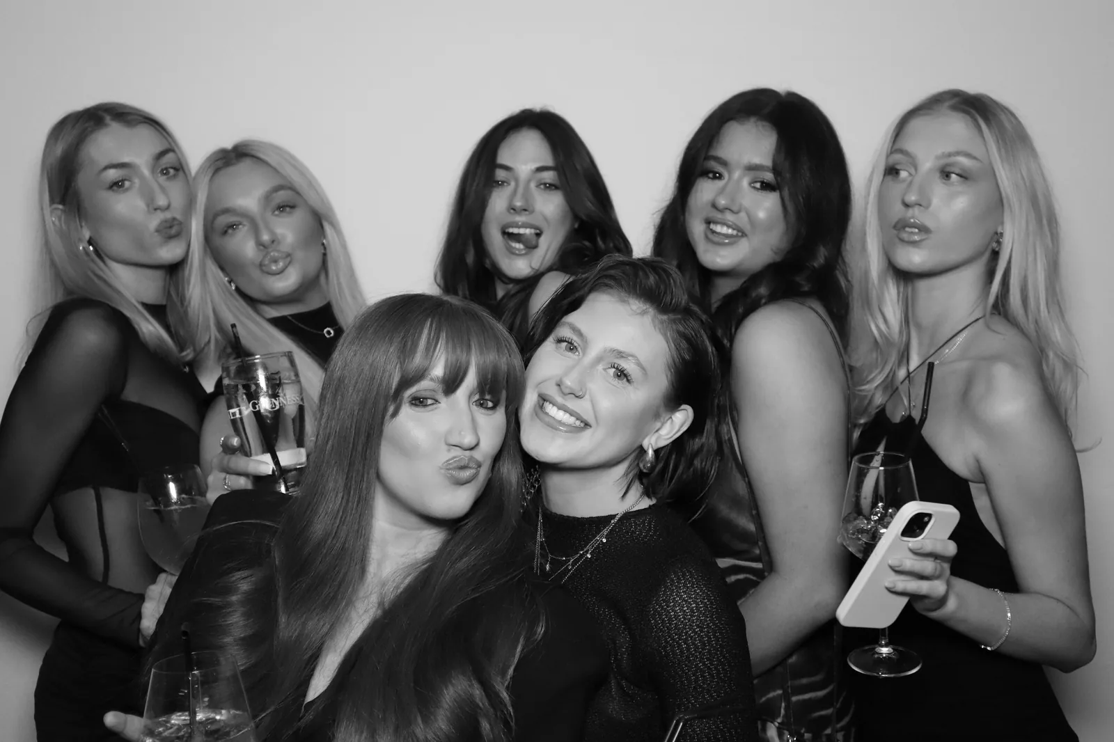 Group of wedding guests posing together at a glam photo booth in Ireland, black-and-white studio lighting portrait